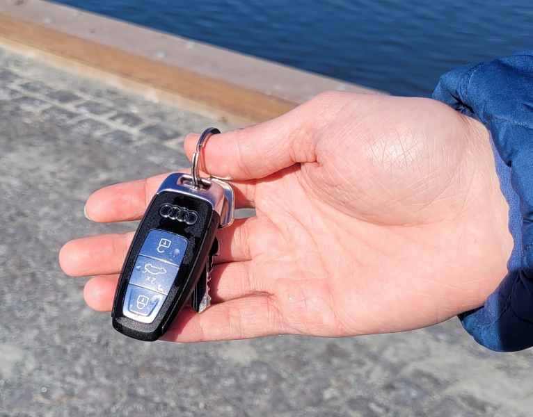 Eine Hand zeigt einen nassen Funkschlüssel der Marke Audi.