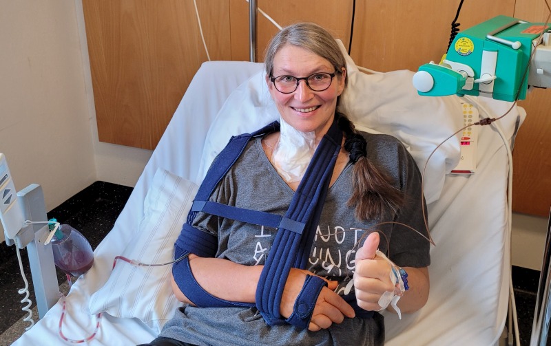 Eine frisch operierte Frau mit bandagiertem rechten Arm nach einer Schulteroperation (Schulter-TEP)