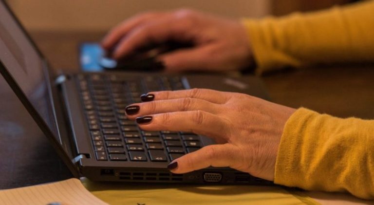 Schreibende Frauenhände auf einer Tastatur