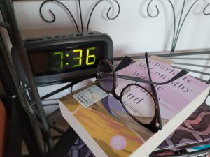Das Buch "Wo die Wölfe sind" vor einem Wecker mit Lesebrille