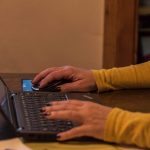 Zwei Frauenhände tippen auf Laptop-Tastatur