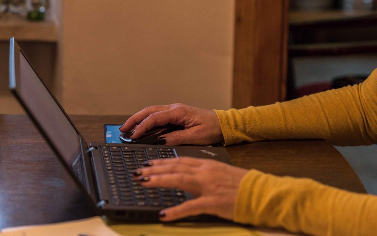 Zwei Frauenhände tippen auf Laptop-Tastatur