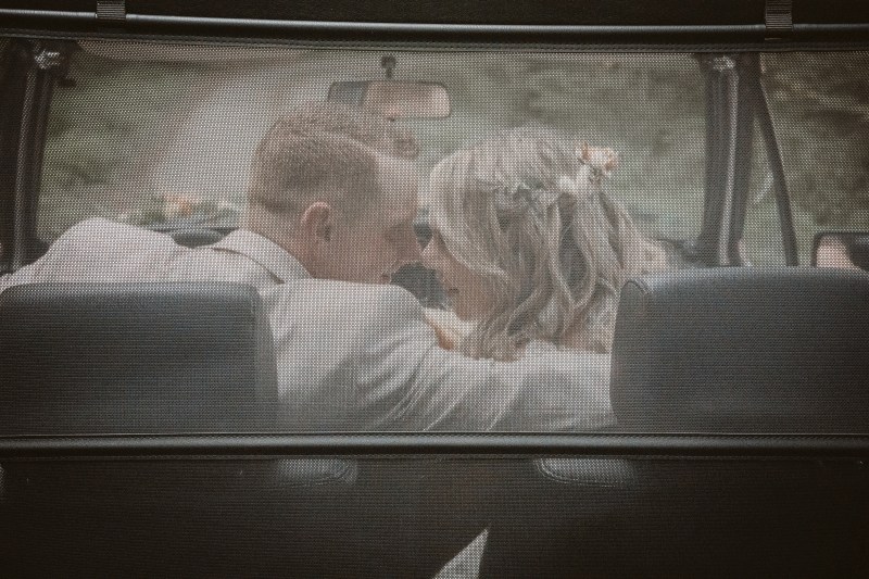 Brautpaar von hinten im Auto