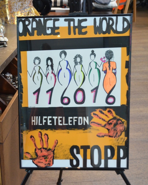 Kunstdruck, Hochformat, Titel oben: ORANGE THE WORLD, darunter fünf stilisierte Frauen, deren Füße übergehen in die Zahlen 116016
darunter Aufschrift HILFETELEFON mit zwei orangenen Händen und rechts unten der Aufruf STOPP