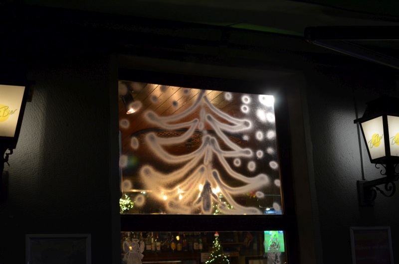 Ein aufgesprühter Weihnachtsbaum an einem Oberlicht einer Kneipe.