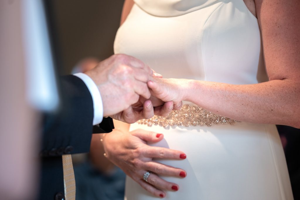 Bräutigam steckt seiner Braut den Ring an