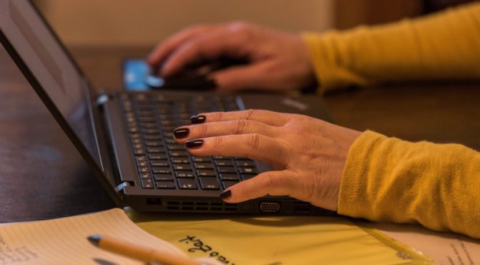 Tippende Frauenhände auf einer Laptoptastatur