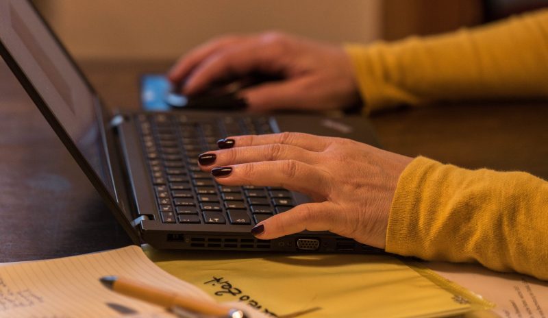 Tippende Frauenhände auf einer Laptoptastatur