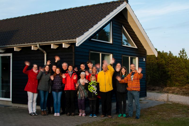 Gruppenbild einer Familie vor einem dänischen Ferienhaus