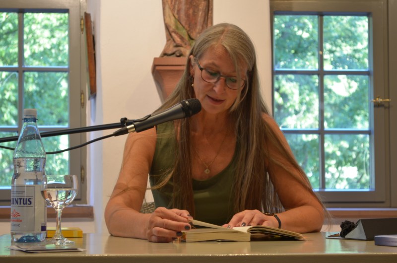 Autorin mit langen Haaren liest aus ihrem Buch