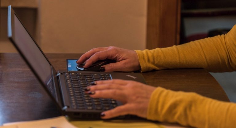 Zwei Frauenhände auf einer Tastatur
