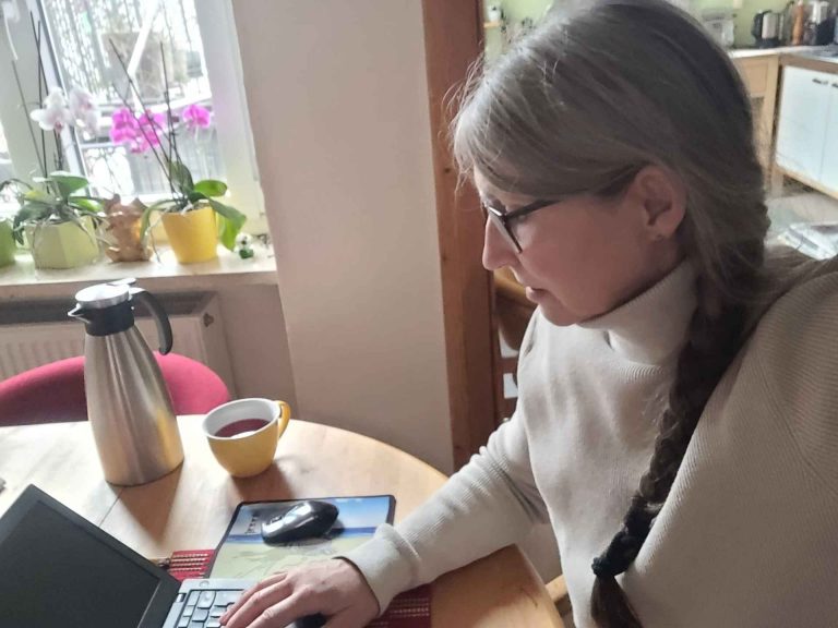 Frau mit langem Zopf schreibend am Laptop