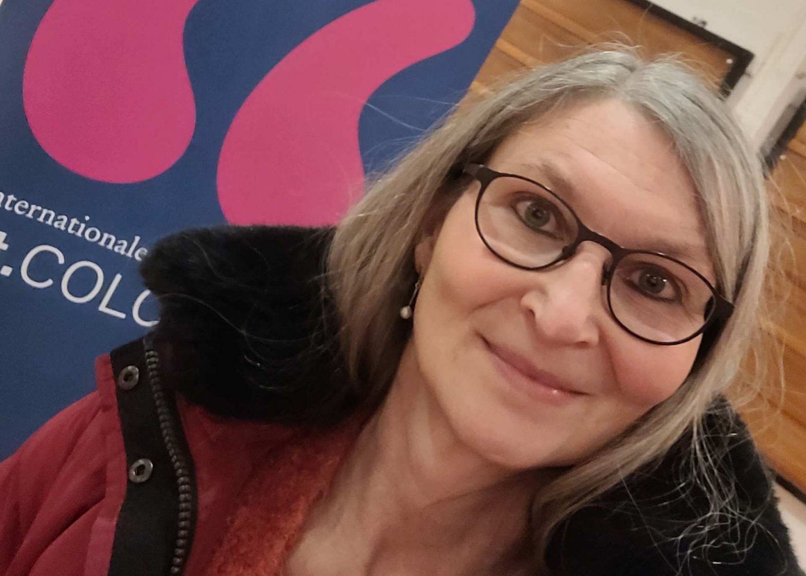 Frau mit Brille vor dem lit.Cologne Plakat