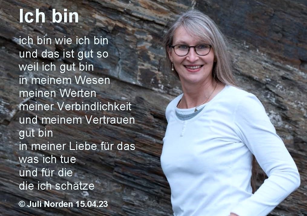 Frau ,mit langen Haaren lächelt in die Kamera vor Schieferwand