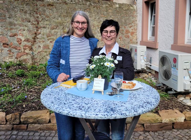 Zwei Frauen an einem Stehtisch im Freien