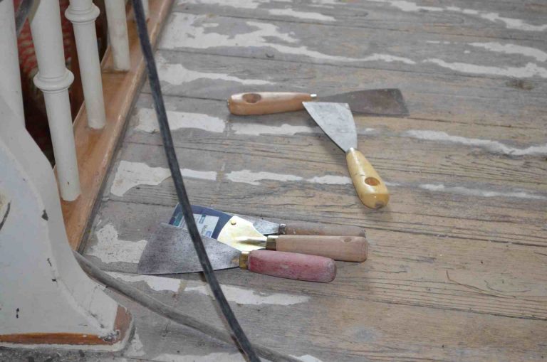 vier Spachtel auf unbearbeitetem, rohem Holzboden