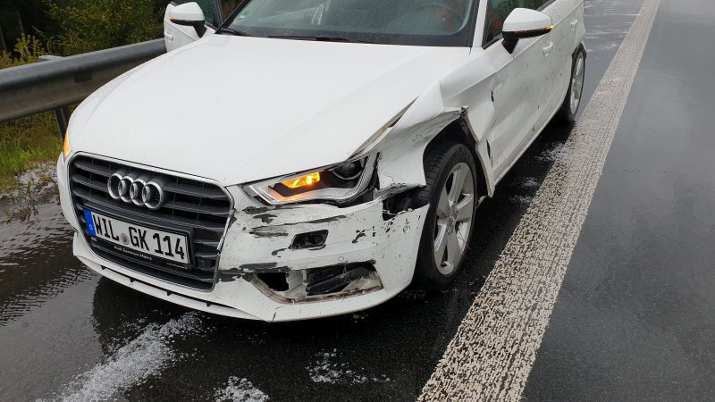 Ein weißer Audi mit starken Front und Seitenschaden auf der Fahrerseite