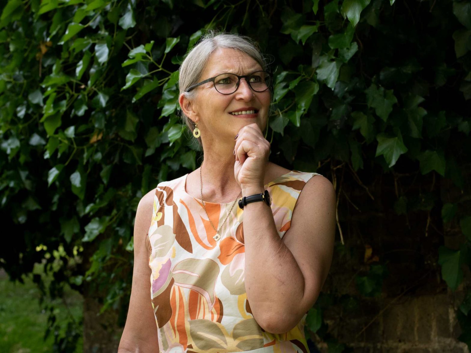 Frau grübelt und fasst sich ans Kinn
