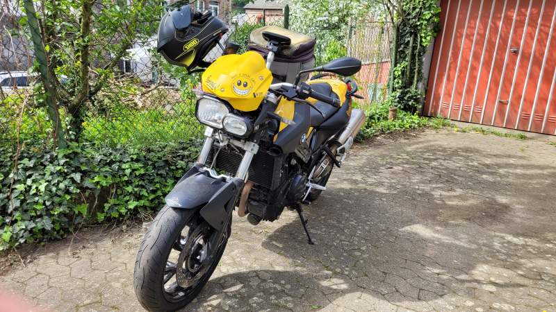 Eine BMW F800R in gelb-schwarzer Lackierung vor einer Garage.