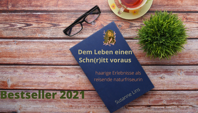 Holztischplatte mit Buch, Brille und Teetasse