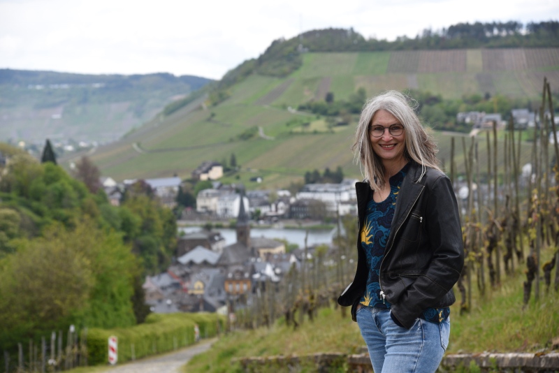 Frau mit wehenden Haaren oberhalb der Mosel, im Hintergrund Traben-Trarbach