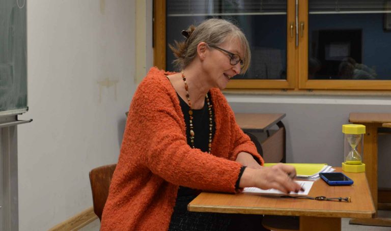 Dozentin für Kreatives Schreiben am Pult in einer Klasse