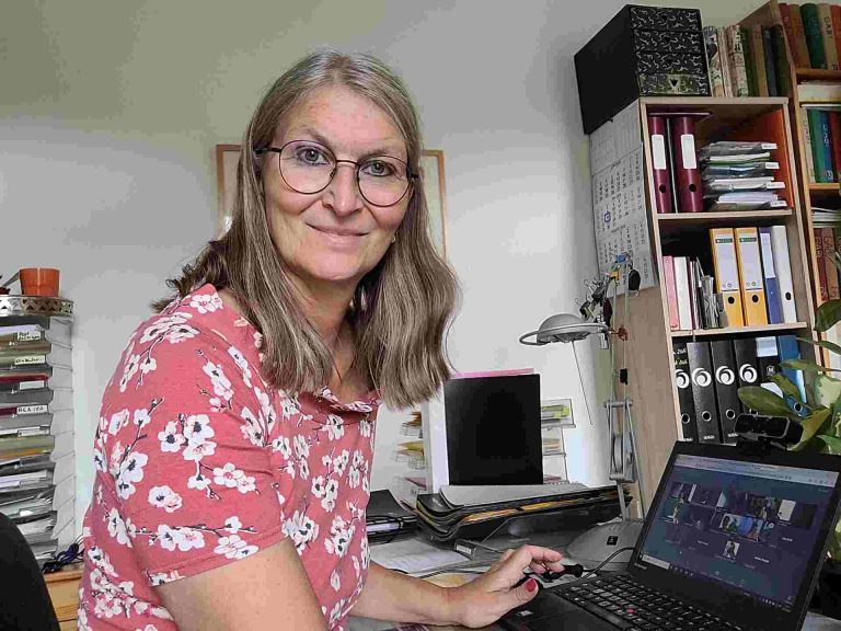 Frau an Schreibtisch beim Arbeiten am Laptop