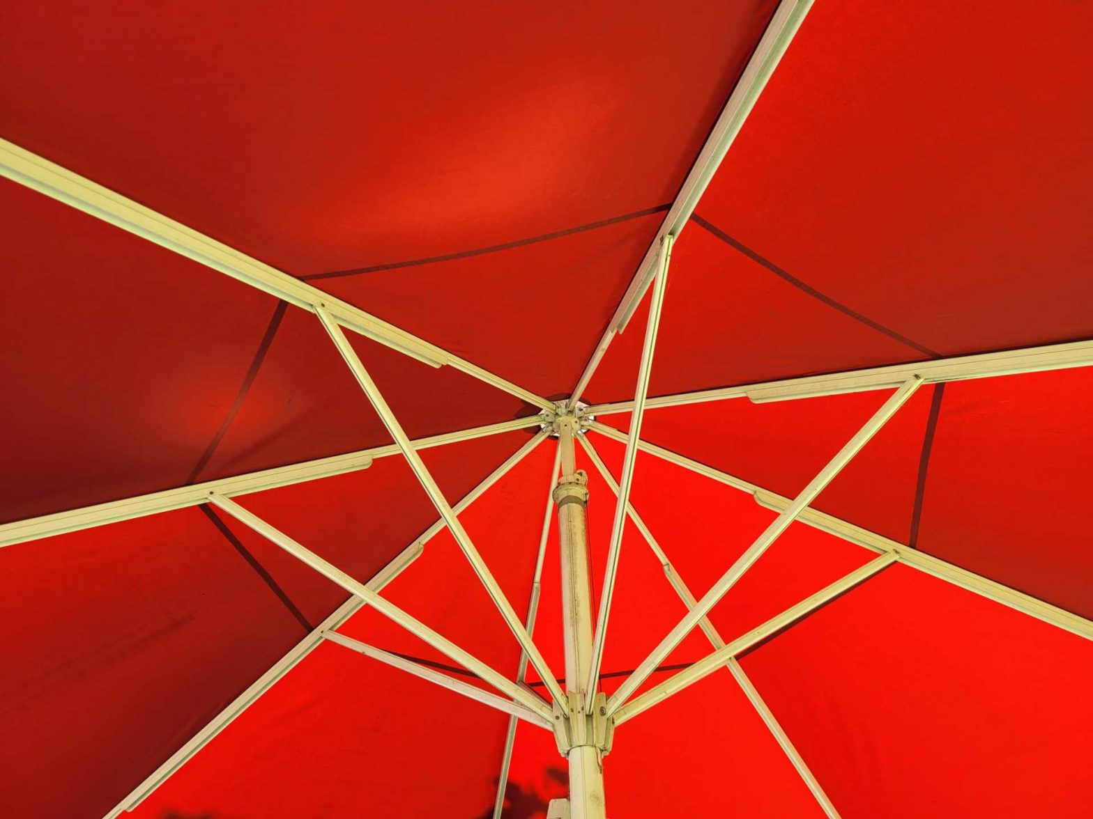 roter Sonnenschirm von innen mit weißem Gestänge
