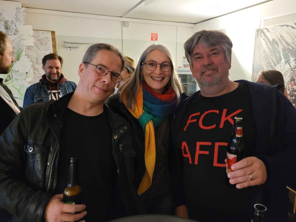 Autoren Sean H. und Tom Fuhrmann mit ihrer Lektorin Gabi Kremeskötter, Männer halten ein Bier in der Hand