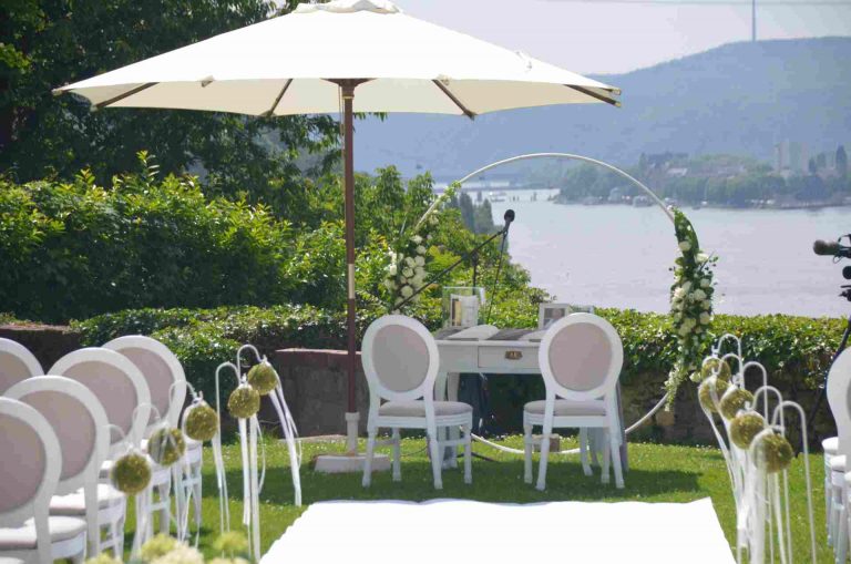 Zwei Stühle für Brautpaar unter Sonnenschirm bei einer freien Trauung mit Blick auf den Rhein