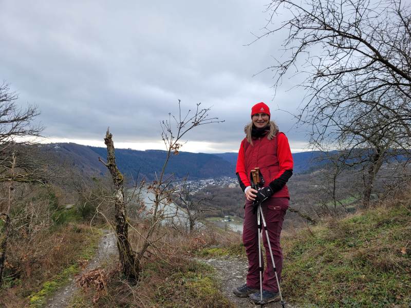 Frau mit Wanderstöcken auf Moselhöhenweg im Winter mit Mütze und Handschuhen