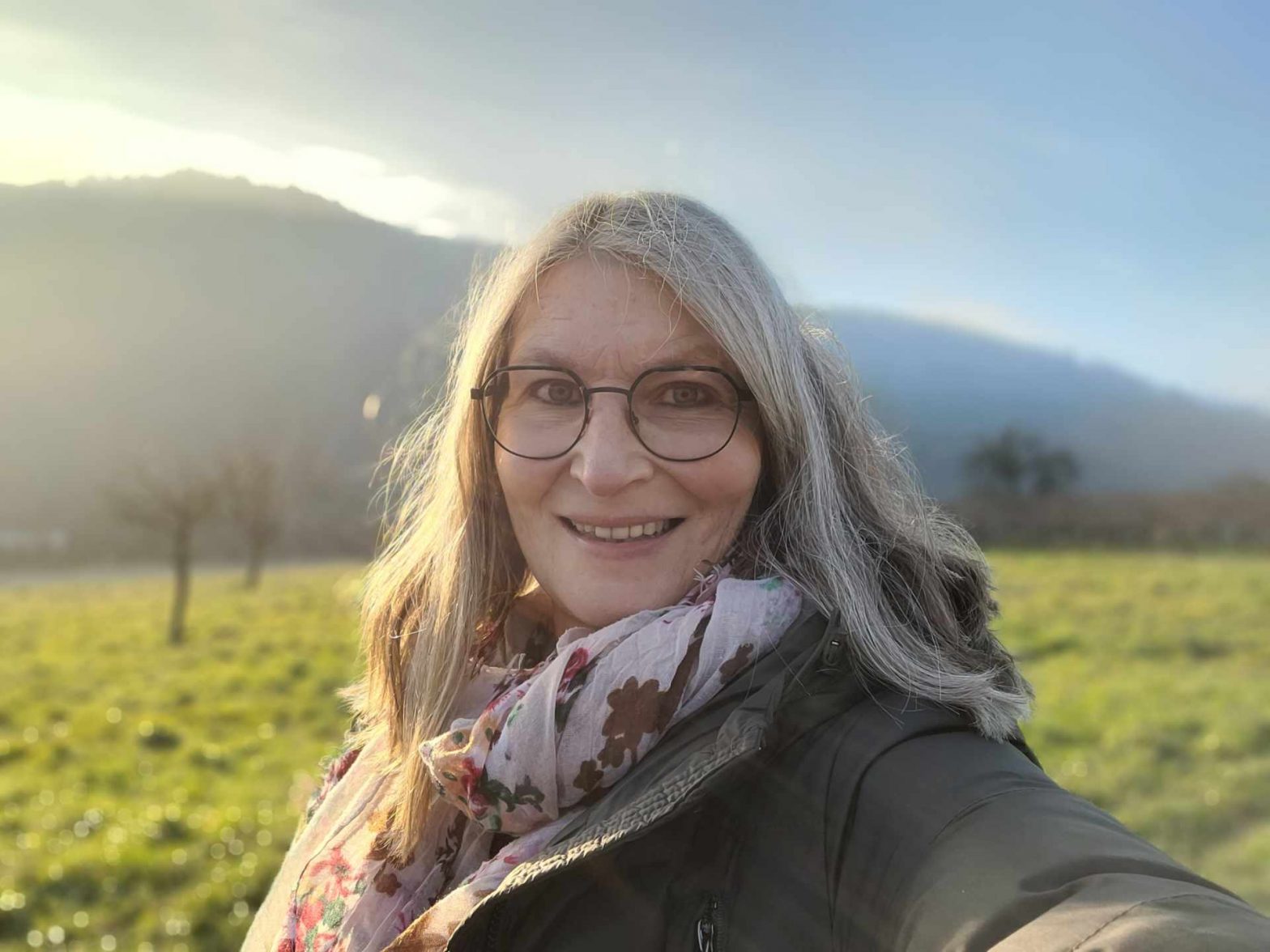 Selfie einer Frau in den Weinbergen am Spätnachmittag, leichte Gegenbelichtung
