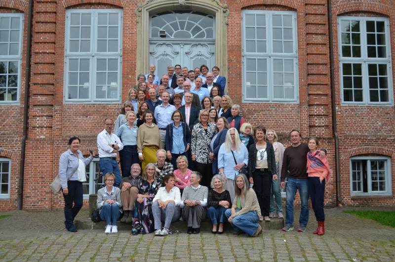 Gruppe von knapp 60 Personen auf Treppe vor einem alten Backsteingebäude