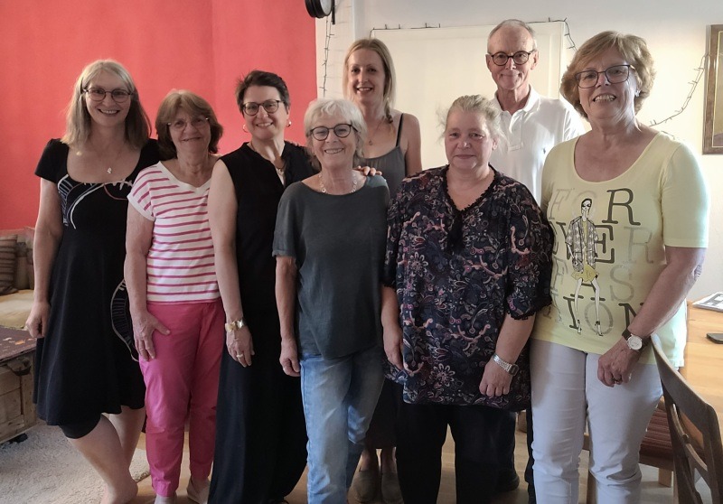 Gruppenfoto: 7 Frauen und ein Mann in einem Wohnzimmer