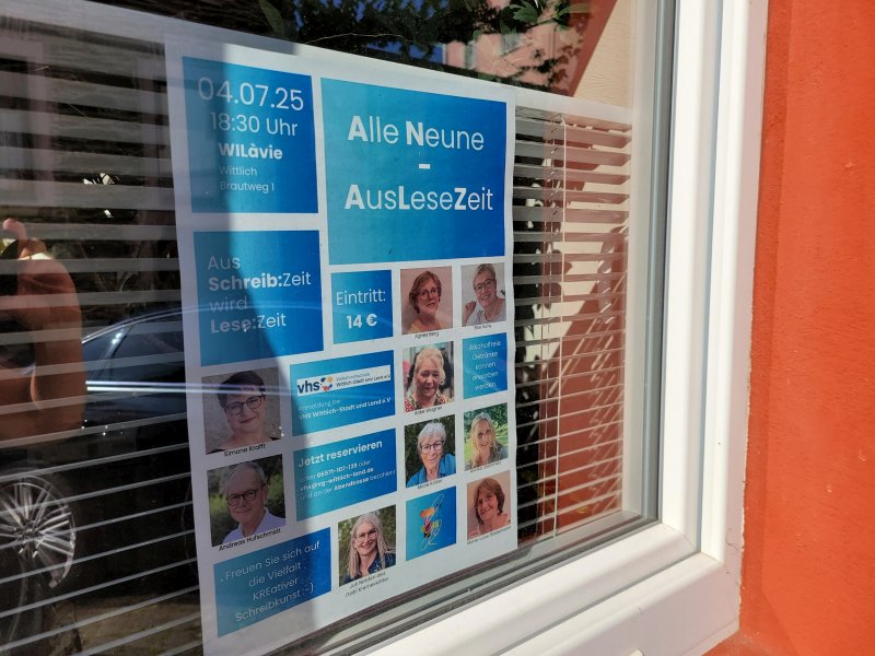 Werbeplakat für eine Gemeinschaftslesung im Fenster eines Wohnhauses
