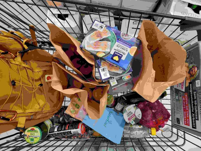 Gefüllter Einkaufswagen in einem Supermarkt mit verschiedenen Lebensmitteln