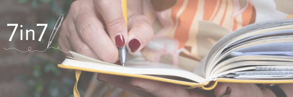 Schreibende Hand auf Notizbuch, daneben Schriftzug "7in7"