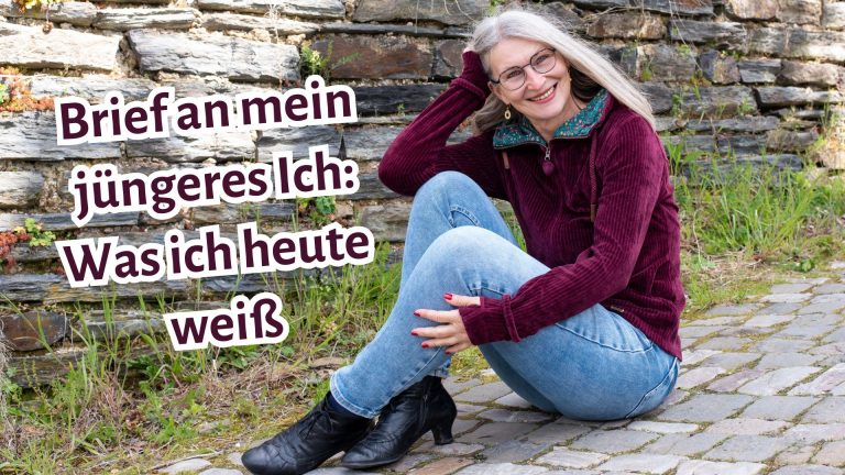 Frau sitzt auf Kopfsteinpflaster und lächelt in die Kamera, daneben Schriftzug: "Brief an mein jüngeres Ich: Was ich heute weiß"