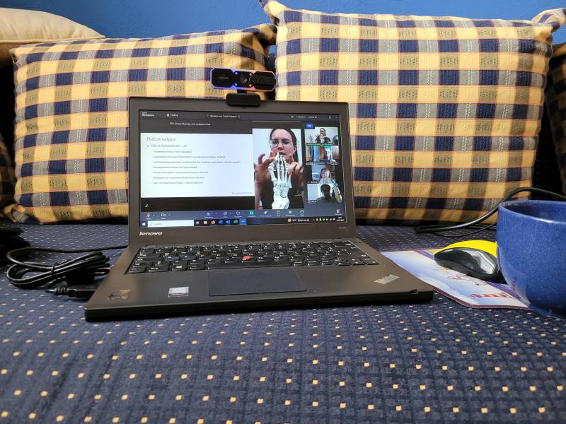 Laptop auf einem Sofa bei einem Online-Meeting