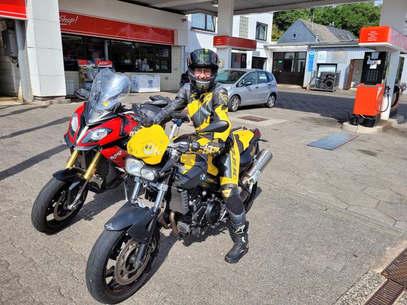 Gabi Kremeskötter in Lederkombi auf ihrem Motorrad an einer Tankstelle.