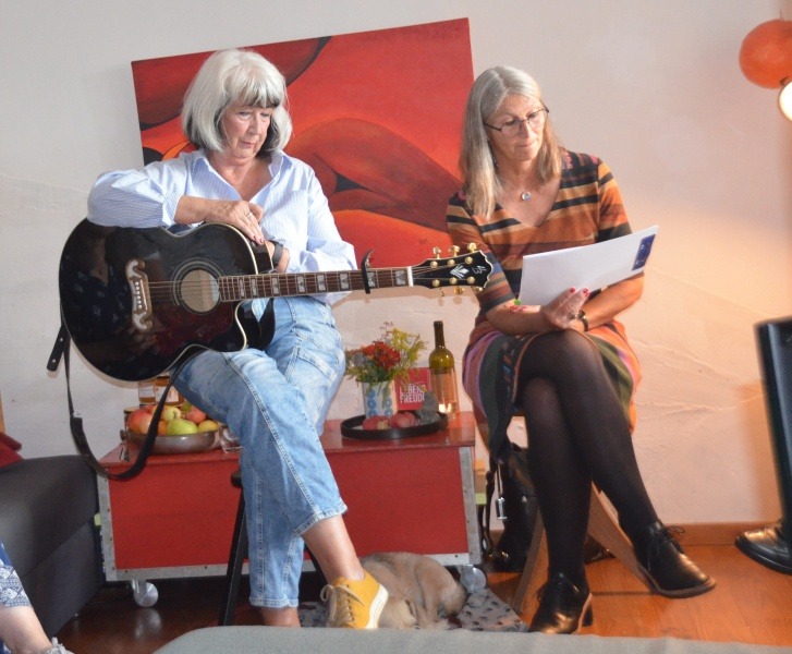 Zwei Frauen bei ihrer musikalischen Lesung: Gitarre und Text.