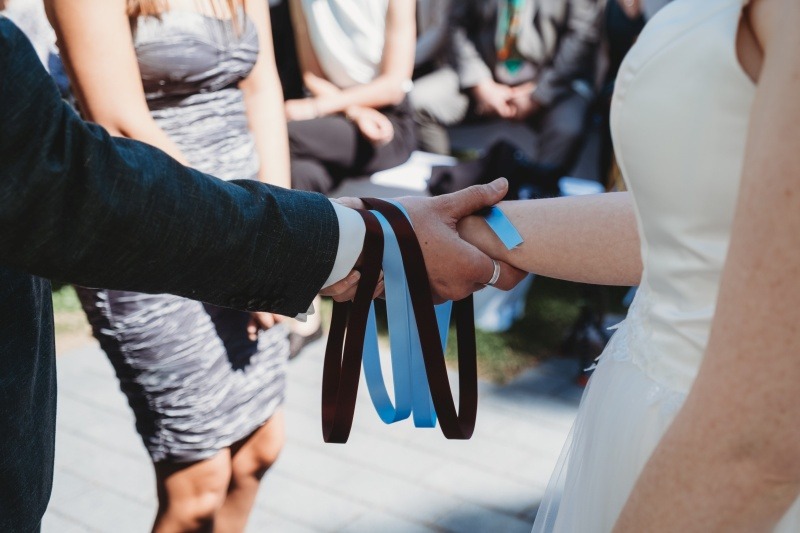 Wrap Handfasting Anleitung Schritt 3: Das zweite Band des WRAPs wird gelegt von der Schwester der Braut