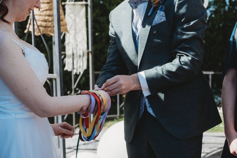 Wrap Handfasting Anleitung Schritt 5: Der Bräutigam wickelt sein Band um die Hände.