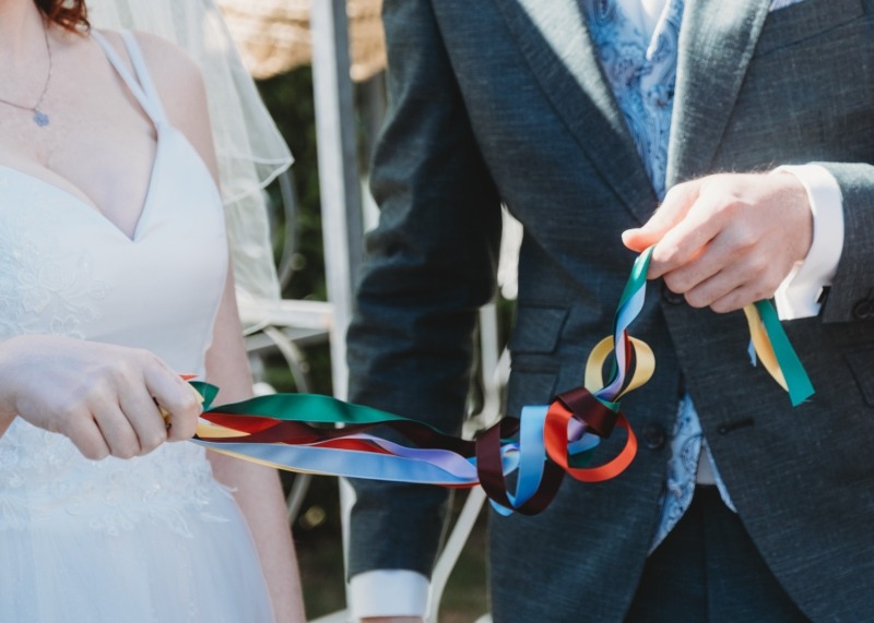 Wrap Handfasting Anleitung Schritt 6: Braut und Bräutigam ziehen die Bänder mit der rechten Hand zu sich.