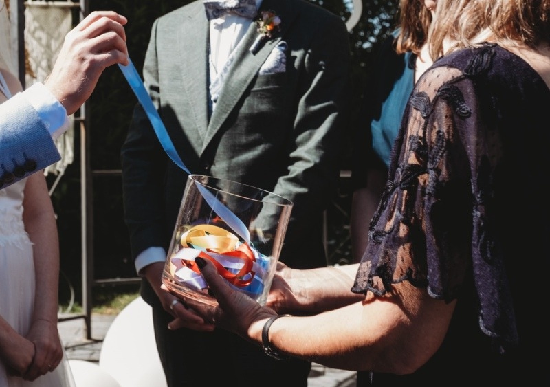Anleitung Schritt 1: Die Bänder für den Handfasting-Knoten WRAP liegen in einem Glas, das erste wird herausgenommen.