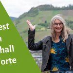 Gabi Kremeskötter steht mit nach oben gerichteten Handflächen in einem Weinberg an der Mosel - daneben steht "Manifest zum Widerhall der Worte"