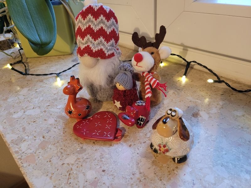 Wichtel und andere kleine Deko-Tiere auf einer Fensterbank mit Lichterkette