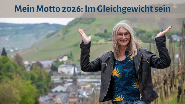 Gabi Kremeskötter steht mit erhobenen Händen vor den Weinbergen an der Mosel, ihre Hände bilden eine Waage, darüber der Text: "Mein Motto 2026: Im Gleichgewicht sein"