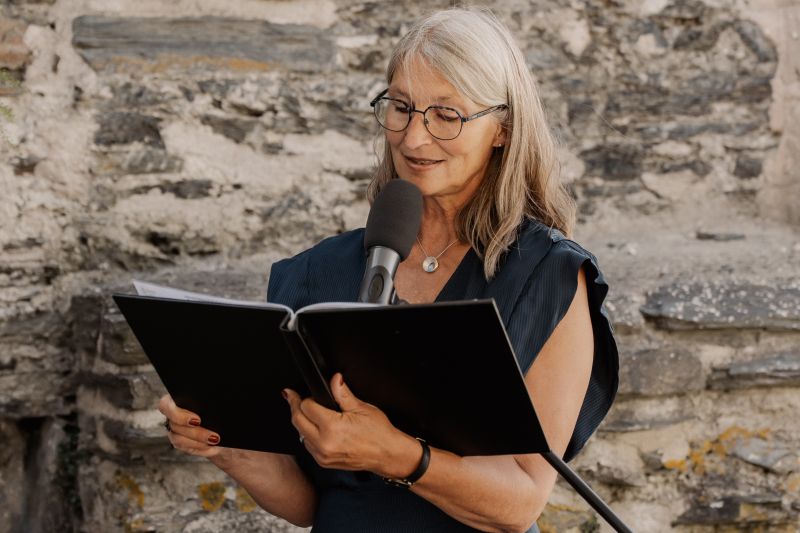 Freie Rednerin Gabi Kremeskötter liest die Traufragen vor, in der Hand ihr Skript.