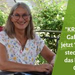Gabi Kremeskötter lächelt in die Kamera, sitzt auf einem Terrassenstuhl mit rotem Polster und blumigem T-Shirt am Laptop. Rechts daneben der Text: "KREativ mit Gabi" heißt jetzt "Was in dir steckt" - und das hat einen Grund."